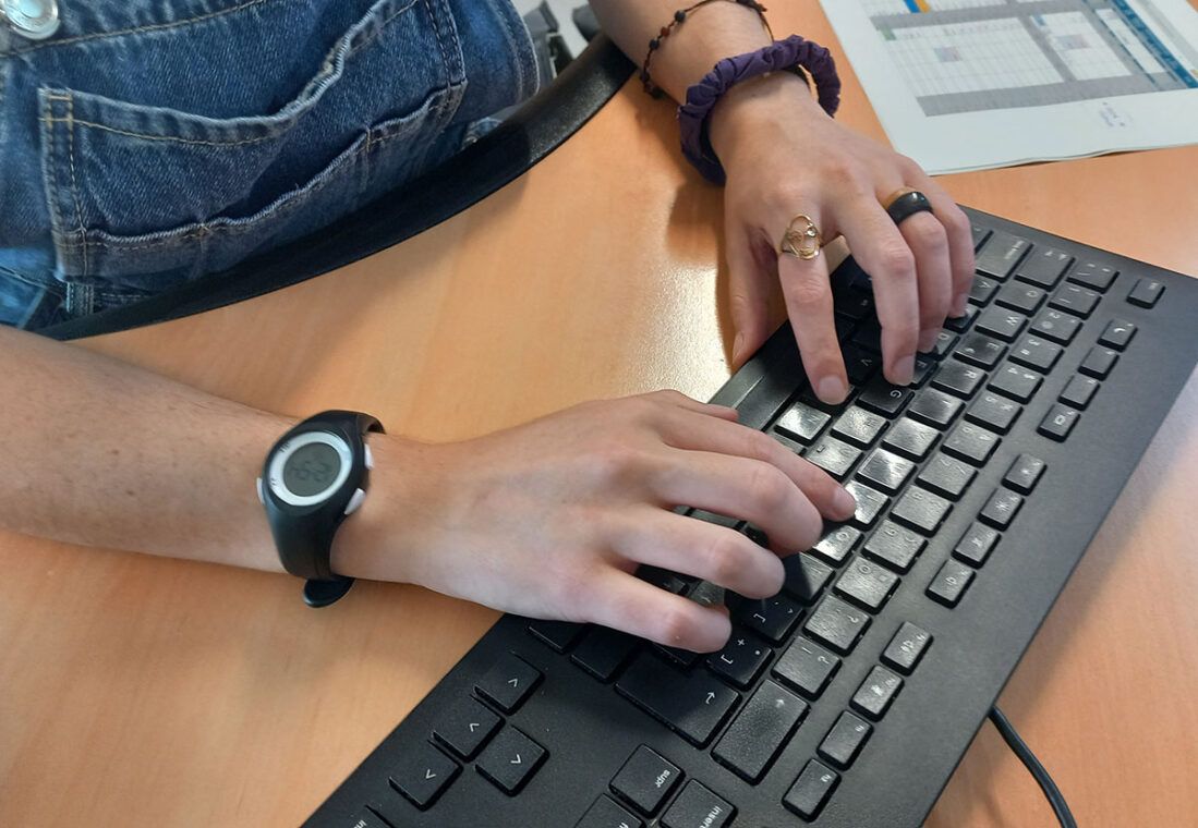 Una persona escribe en un teclado de ordenador.